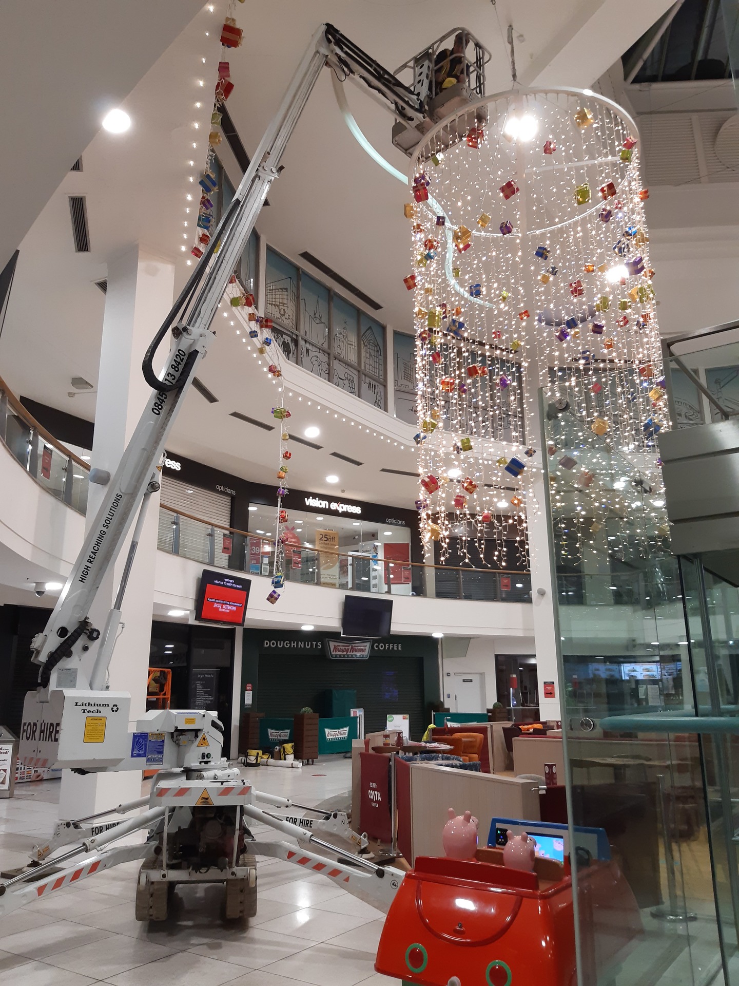 Scarlett Grace, 13m Lithium hybrid tracked spiderlift cherrypicker from High Reaching Solutions, assisting with the installation of Christmas decorations inside a shopping centre.