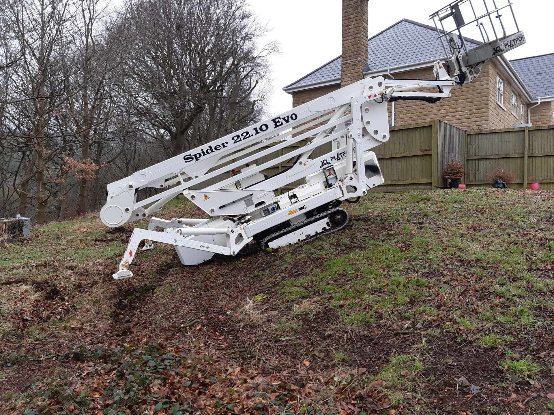 Selina, High Reaching Solutions 22m Lithium hybrid tracked spiderlift cherrypicker climbing a steep grass bank after assisting arborists with tree removal near North Yorkshire