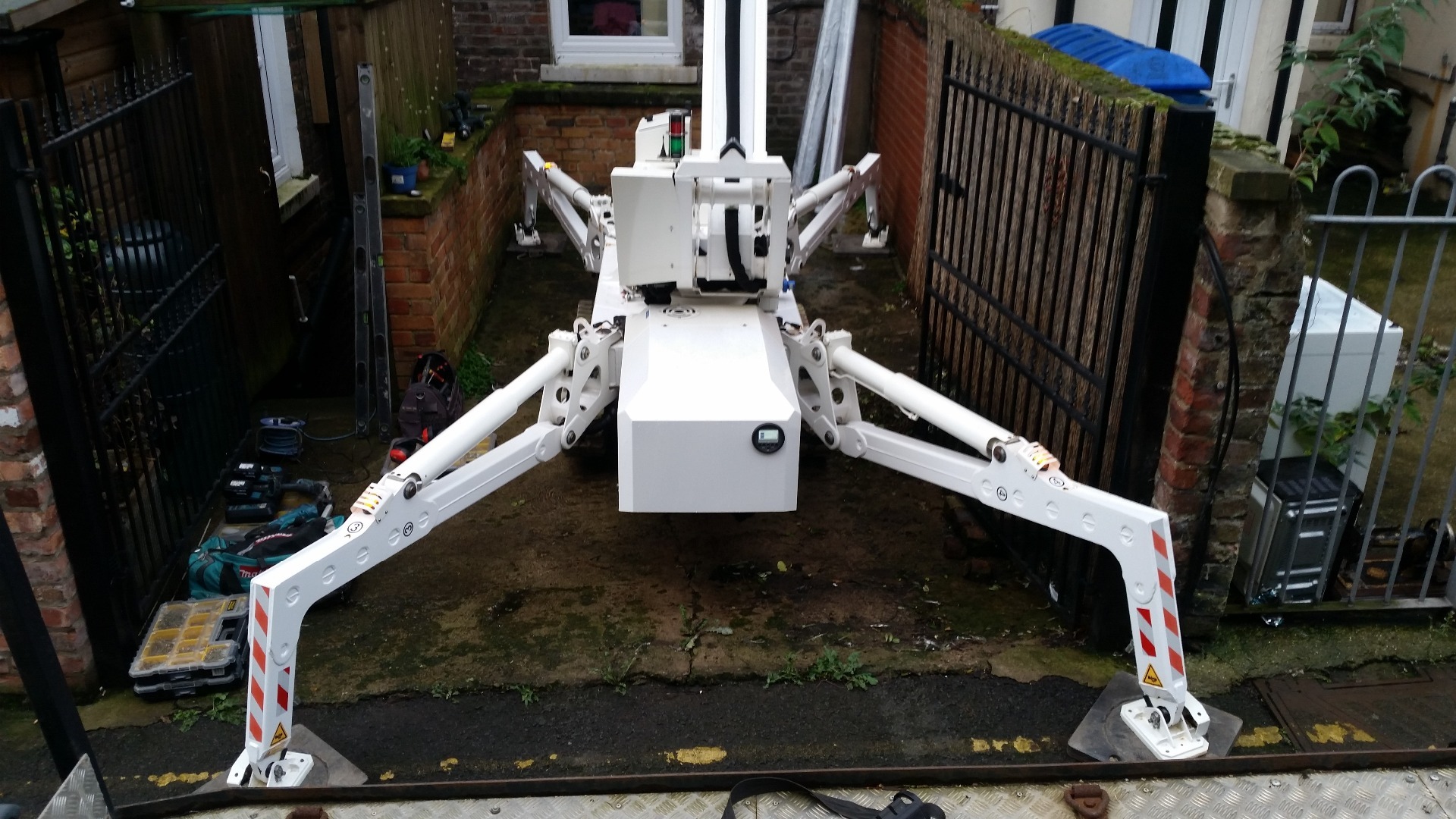 Tracked spider cherrypicker on narrow restricted hard-standing assisting contractors.
